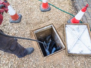 Technician inspecting underground sewer lines for sewer backup prevention in strata properties.