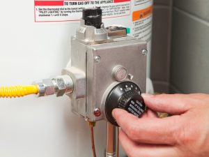 Hand adjusting hot water system controls, troubleshooting why the hot water system is not working.
