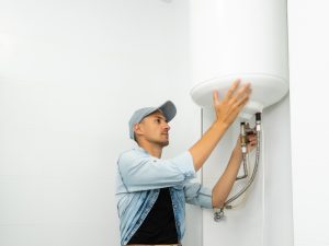 A technician inspecting a wall-mounted water heater, ensuring proper function before attempting to reset water heater.