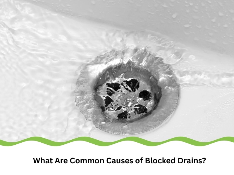 causes of blocked drains shown in a close-up of a clogged metal sink drain with water swirling around
