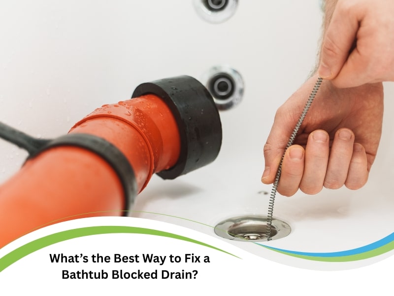 A hand removes a bathtub blocked drain using a flexible drain snake tool.