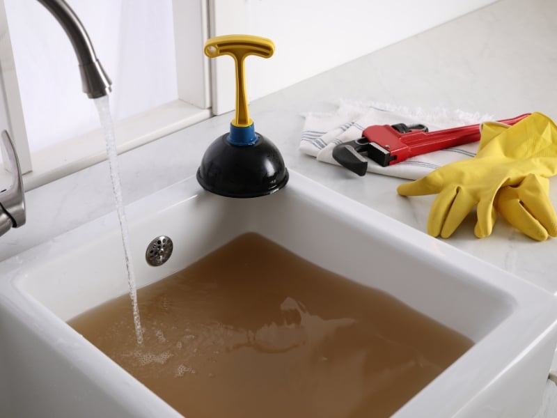 Kitchen sink blocked drain causing dirty water to fill up while using a plunger and repair tools